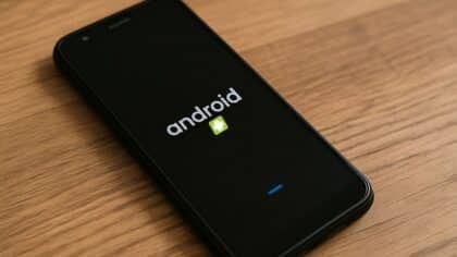 Un smartphone Android en cours de redémarrage sur une table en bois.