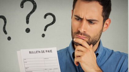 Un homme soucieux regarde son bulletin de salaire avec des points d’interrogation dessinés en arrière-plan.