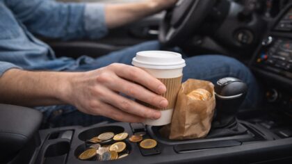 Personne prenant un gobelet de café, illustrant une habitude quotidienne aux petites dépenses répétées