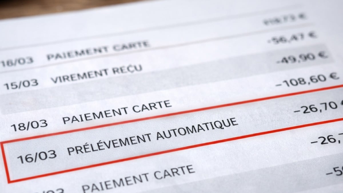 Personne consultant un relevé bancaire sur une table, illustrant une ligne de dépense répétée et souvent ignorée